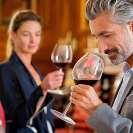 a man drinking a glass of wine